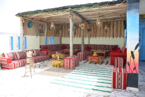 a pavilion with red couches and tables in a room at Azour House in Taghazout