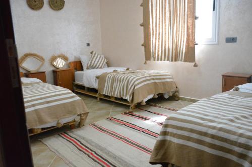 a bedroom with two beds and a window at Azour House in Taghazout