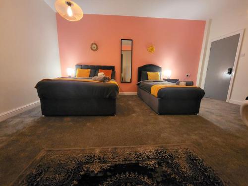 a room with two beds and a mirror at Stay Sleep Rest - Oldham in Oldham