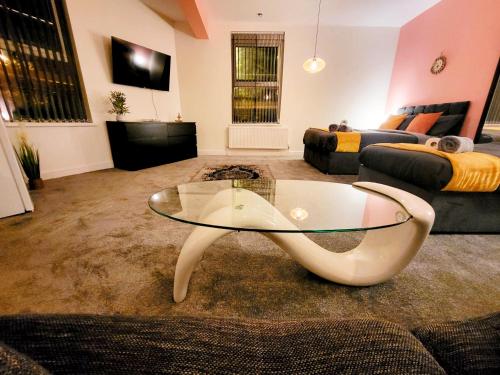 a living room with a glass table and a couch at Stay Sleep Rest - Oldham in Oldham