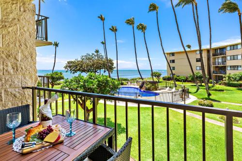 a table on a balcony with a view of the ocean at Kanai A Nalu 214 in Wailuku