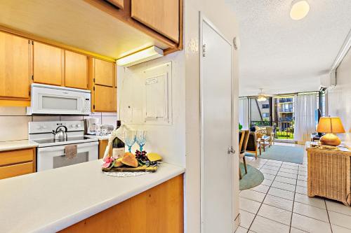 a kitchen with a counter with a plate of food at Kanai A Nalu 214 in Wailuku