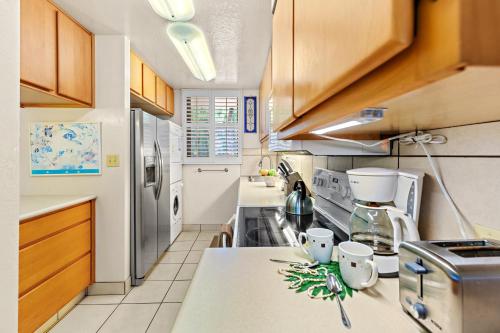 a kitchen with wooden cabinets and a counter top at Kanai A Nalu 214 in Wailuku