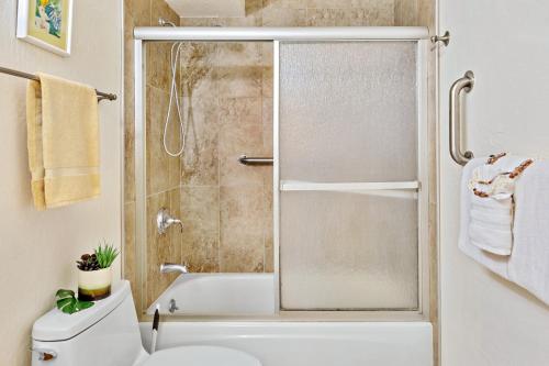 a bathroom with a white toilet and a shower at Kanai A Nalu 214 in Wailuku