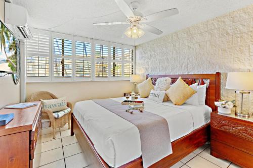 a bedroom with a bed with a ceiling fan at Kanai A Nalu 214 in Wailuku