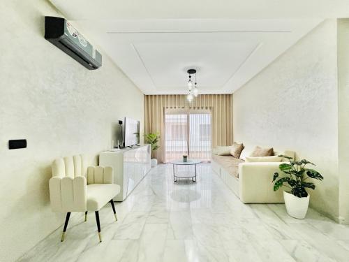 a white living room with a couch and chairs at Appartement Dahlia - Haut Standing - Mohammedia Natura Living in Mohammedia