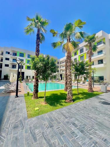 a resort with palm trees and a swimming pool at Appartement Dahlia - Haut Standing - Mohammedia Natura Living in Mohammedia