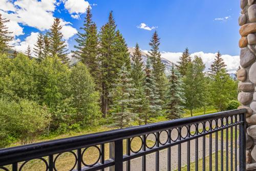 a balcony with a view of trees and mountains at Outstanding Mountain Condo WATERSLIDE and HOT TUB managed by Little Sister Getaways in Canmore