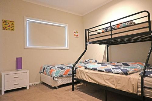 a bedroom with two bunk beds and a window at Rosebud Beach House in Rosebud