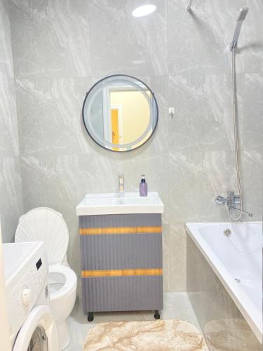 a bathroom with a sink and a mirror and a toilet at Б241 Нурлы-жол in Promyshlennyy