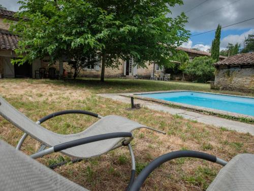 une chaise assise dans l'herbe à côté d'une piscine dans l'établissement Fond de Bacquey, à Léogeats
