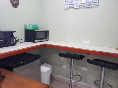 a kitchen with a counter with a microwave and a toilet at DB Tower Vacation Rental in Belize City