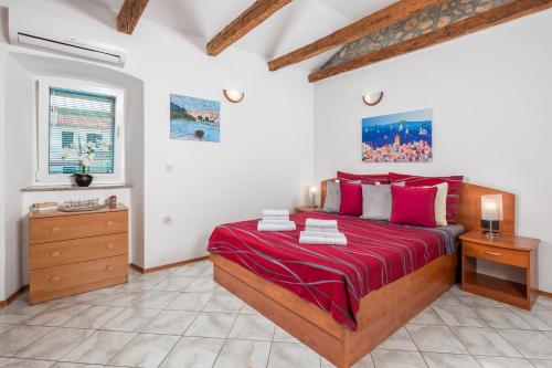 a bedroom with a large bed with red sheets at Studio Punat 15451a in Punat