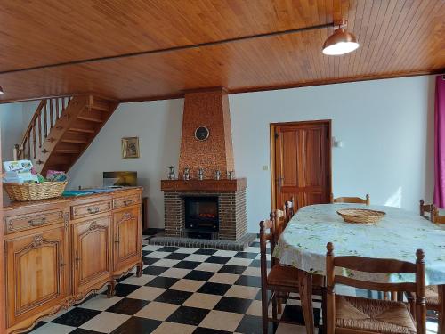 une salle à manger avec une table et une cheminée dans l'établissement Maison spacieuse avec jardin, BBQ, table de ping-pong, proche commerces, pour 9 personnes et bébés - FR-1-581-96, à La Bazoche-Gouet