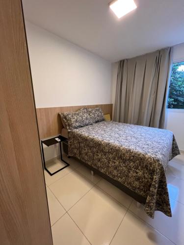 a small bedroom with a bed and a window at Confortável 2 quartos a 4 min da orla in Santa Maria