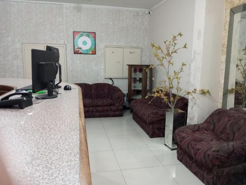 a living room with two couches and a television at Hotel Lisboa II in São José dos Campos