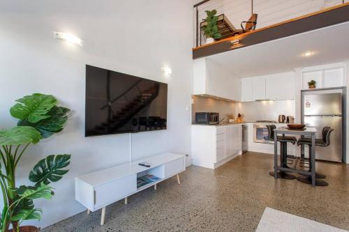 a kitchen with white cabinets and a table in a room at Ellens Corner near New Kings Square in Fremantle