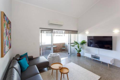 a living room with a couch and a flat screen tv at Ellens Corner near New Kings Square in Fremantle