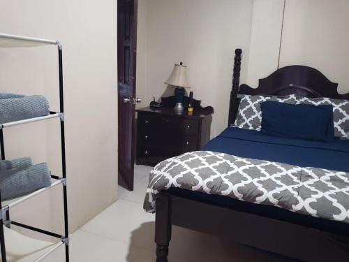 a bedroom with a bed and a dresser with a lamp at DB Tower Vacation Rental in Belize City