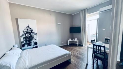 a bedroom with a bed and a desk with a clock on the wall at Best Stay - Central Station Suite Apartments in Bari