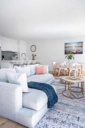 a white living room with a white couch and a table at Sea Breeze Retreat in Cape Paterson