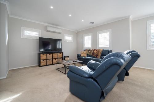 a living room with a blue couch and a tv at Waterview Inverloch in Inverloch