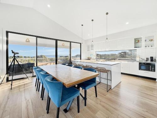 a large kitchen with a wooden table and blue chairs at Shelley Beach Retreat Kilcunda in Kilcunda