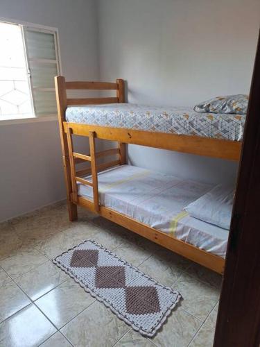 two bunk beds in a room with a window at Casa acolhedora para descanso in Brotas