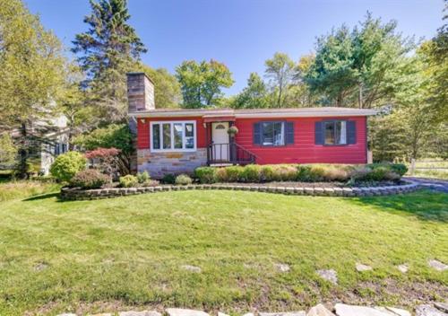 a red house with a lawn in front of it at 3 BR 2 BA Modern home with private hot tub, fire pit and lake view, Dogs ok! in Tobyhanna