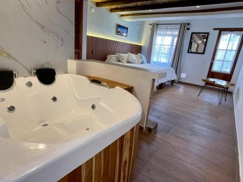 a bathroom with a tub and a bed in a room at Hotel Boutique Cenit in Villa de Leyva