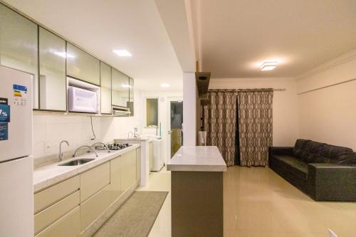 ボンビーニャスにあるEco Village Parkのシンクとソファのあるキッチンのある部屋