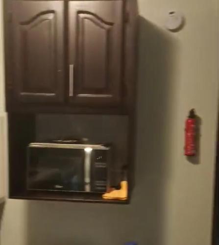 a microwave on the side of a refrigerator at madrigal 1-3br with parking in Santiago de los Caballeros