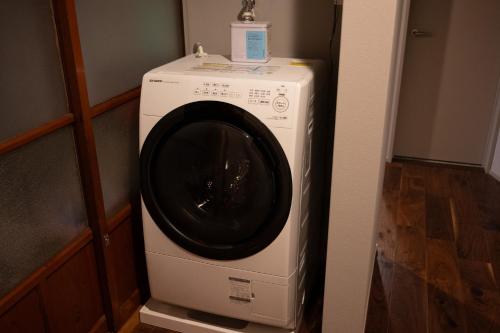 a washer and dryer in the corner of a room at 佐渡古民家ステイ さどまり 大和の家 in Sado