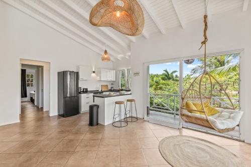 a kitchen and living room with a large window at Cocoloft Curacao in Jan Thiel
