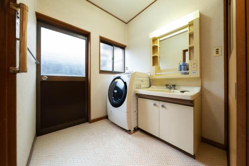 倉敷市にある倉敷の宿Retreat KOBAYASHI 1棟貸切 1日1組限定 11LLDDK 520平米 102年前の伝説の建物 瀬戸内芸術祭2025 直島 美観地区 最大10名 駐車場3台 ベッド8台の洗濯機と洗面台を備えたバスルーム