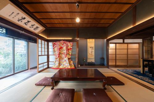 a living room with a table and some windows at Retreat KOBAYASHILegendary 102-Year-Old Whole House in Kurashiki11LLDDK倉敷の宿Retreat KOBAYASHI 1棟貸切 1日1組限定 11LLDDK 520平米 102年前の伝説の建物 瀬戸内芸術祭2025 直島 美観地区 最大10名 駐車場3台 ベッド8台 in Kurashiki