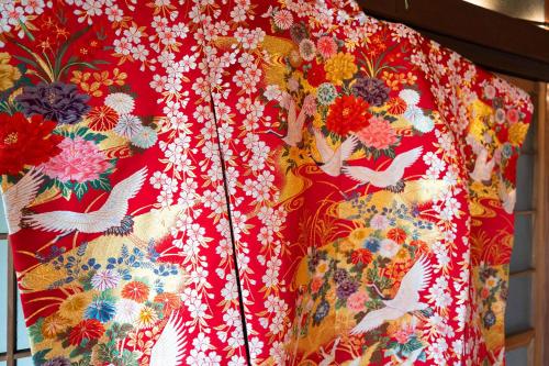 a red dress with flowers and birds on it at Retreat KOBAYASHILegendary 102-Year-Old Whole House in Kurashiki11LLDDK倉敷の宿Retreat KOBAYASHI 1棟貸切 1日1組限定 11LLDDK 520平米 102年前の伝説の建物 瀬戸内芸術祭2025 直島 美観地区 最大10名 駐車場3台 ベッド8台 in Kurashiki