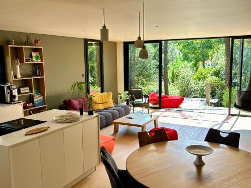 une cuisine et un salon avec une table et des chaises dans l'établissement Maison dans les arbres, proche plage, cheminée, jardin, parking - FR-1-652-46, à Saint-Jean-de-Monts