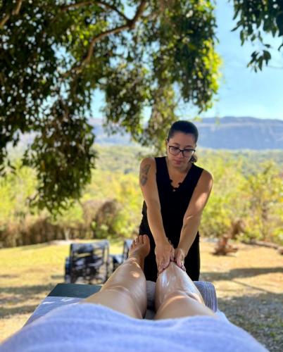 a woman is tying the feet of a man at Segredo da Serra Guest House in Tiradentes