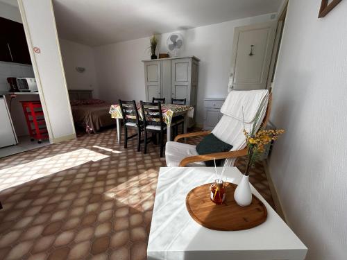 un salon avec une table avec un vase de fleurs dans l'établissement Studio proche centre-ville et Thermes, WIFI, parking - FR-1-541-121, à La Roche-Posay