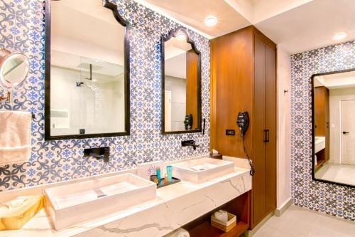 a bathroom with two sinks and a large mirror at Bellafer Collection Hotel & Resort in Rosarito