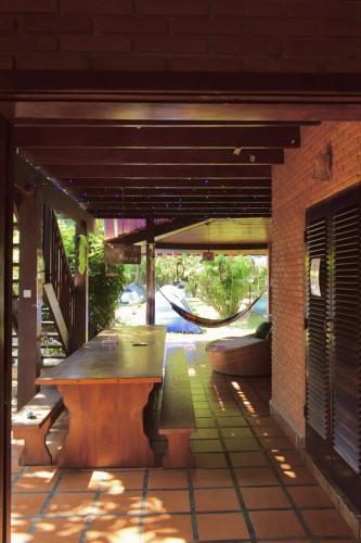 a patio with a wooden bench on a building at Hostel Trópico de Capricórnio - Tenório in Ubatuba