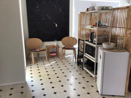 a kitchen with two chairs and a refrigerator at Seahorse in Agnes Water