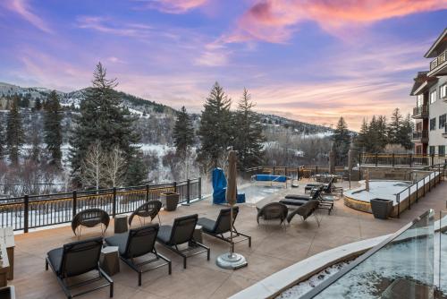 a patio with chairs and a swimming pool on a building at Riverfront Lodge 403 by East West Hospitality in Beaver Creek