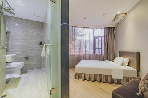 une chambre avec un lit et une salle de bain avec douche dans l'établissement Insail Hotels (Pazhou Exhibition Center KeCun Metro Station Dunhe Road Branch Guangzhou), à Canton