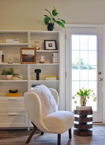 a living room with a chair and a book shelf at Mountain Whispers - Modern Chic Near Shenandoah National Park in Luray