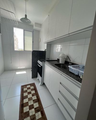 a kitchen with white cabinets and a checkered floor at Lindo 2 quartos a 4 min da orla in Aracaju