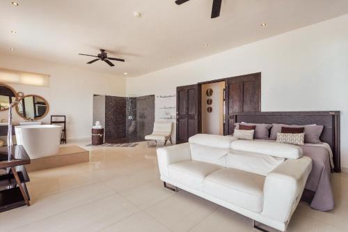 a bedroom with a white bed and a white couch at Casa Javi- Ocean Front located Mid Isla Mujeres in Isla Mujeres