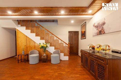 a living room with a staircase and a table and chairs at StayVista at Ruhaniyat in Pahalgām