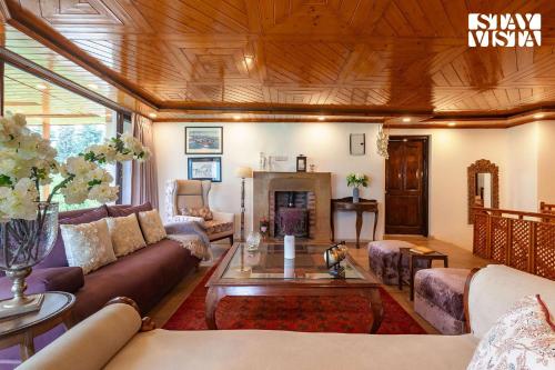 a living room with a couch and a fireplace at StayVista at Ruhaniyat in Pahalgām